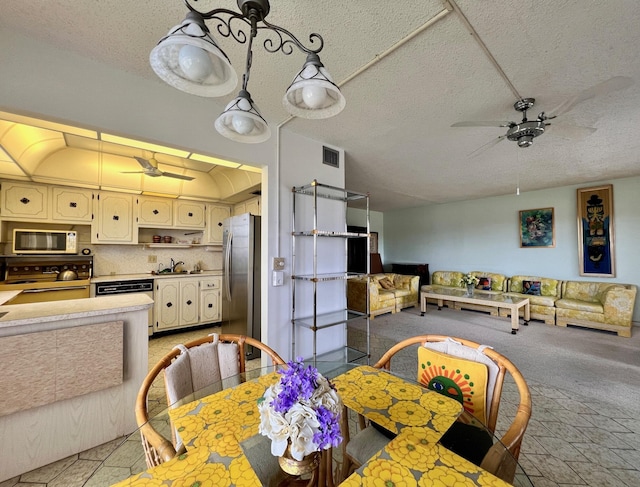 dining room featuring ceiling fan, sink, and a textured ceiling