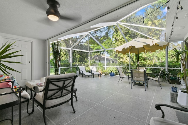 view of patio featuring a lanai and a ceiling fan