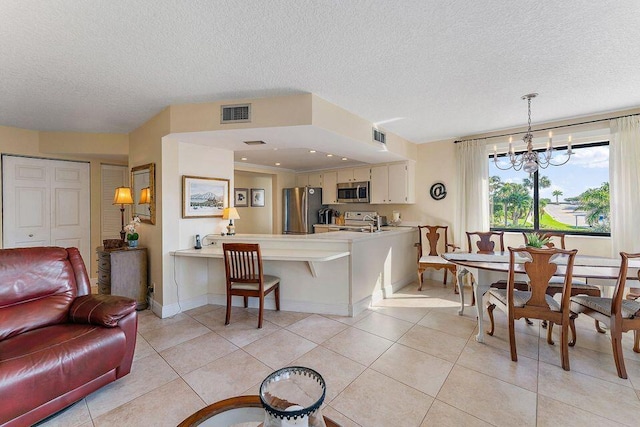 dining area featuring light tile patterned floors, a textured ceiling, baseboards, and a notable chandelier