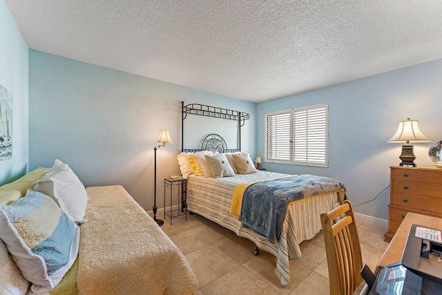 bedroom with baseboards, a textured ceiling, and light tile patterned flooring