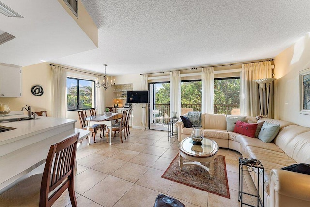 living area with a healthy amount of sunlight, light tile patterned floors, a textured ceiling, and a notable chandelier