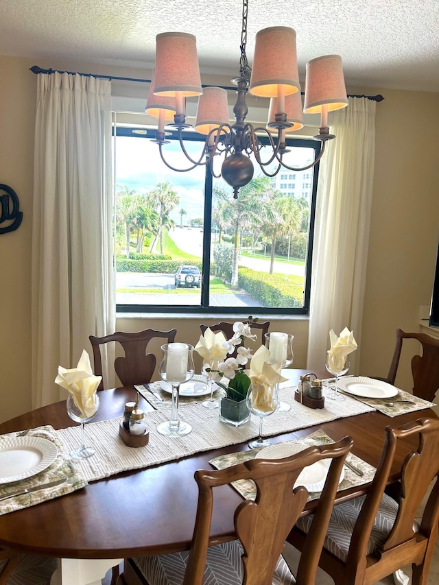 dining area with a textured ceiling and a notable chandelier