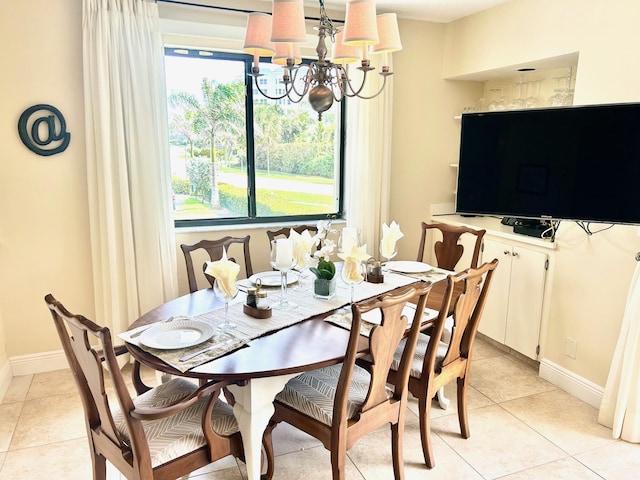 dining room with light tile patterned flooring, a notable chandelier, and baseboards