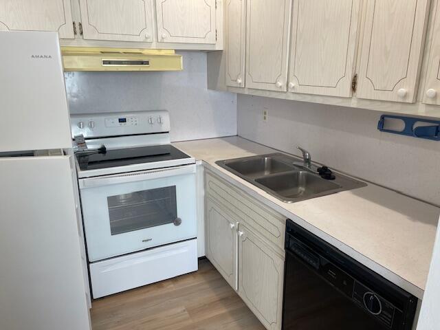 kitchen featuring sink, white appliances, ventilation hood, and light wood-type flooring