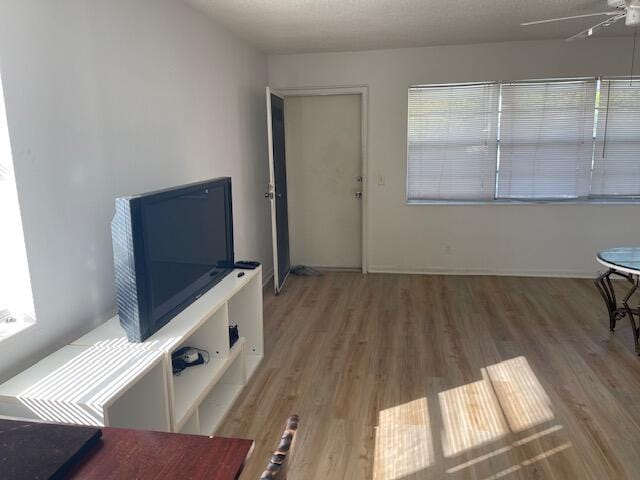 living room featuring hardwood / wood-style floors, a textured ceiling, and ceiling fan