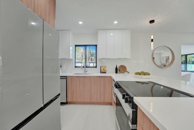 kitchen featuring sink, plenty of natural light, appliances with stainless steel finishes, pendant lighting, and white cabinets