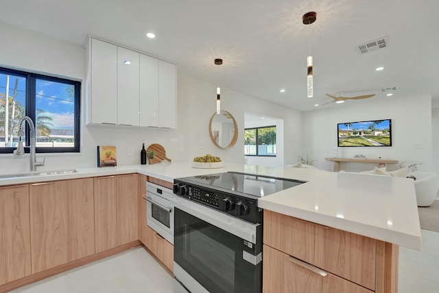 kitchen with pendant lighting, sink, electric range oven, white cabinets, and kitchen peninsula