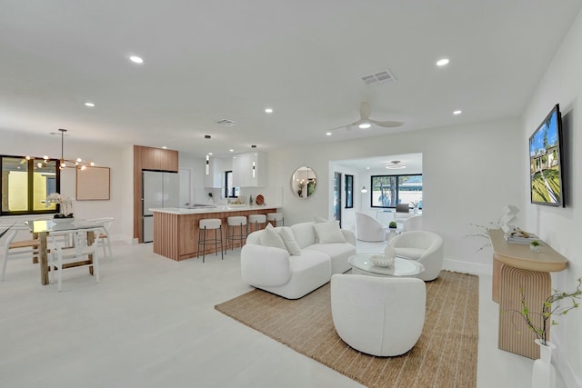 living room featuring ceiling fan with notable chandelier