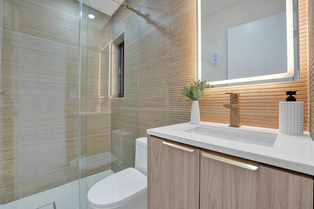 bathroom with vanity, toilet, an enclosed shower, and tile walls