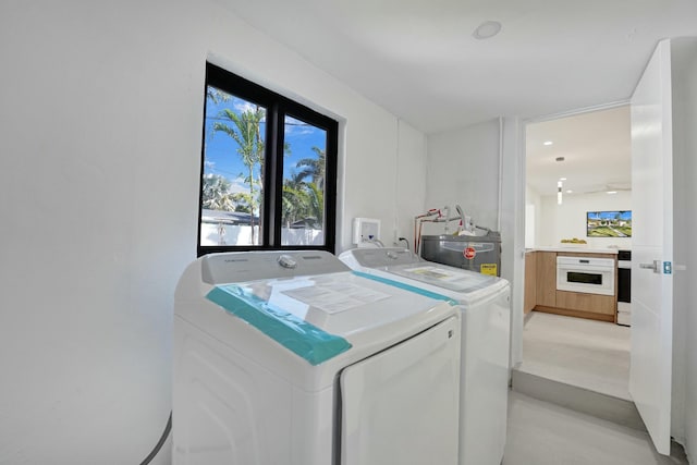 laundry area with water heater and washer and clothes dryer