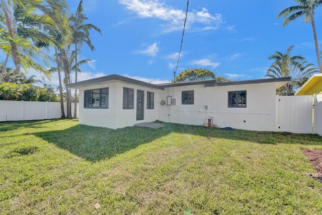 rear view of property with a lawn