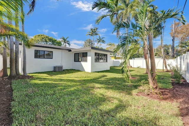 back of property with cooling unit and a yard