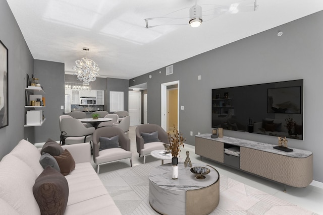 living room with visible vents, a notable chandelier, and baseboards