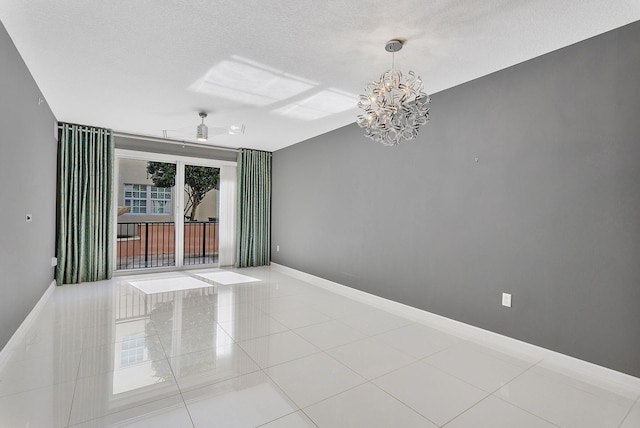 spare room featuring tile patterned flooring, a textured ceiling, baseboards, and ceiling fan with notable chandelier