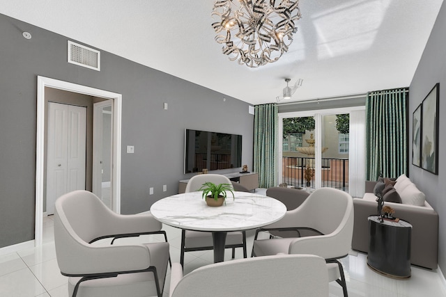 dining area with a chandelier, visible vents, baseboards, and light tile patterned floors