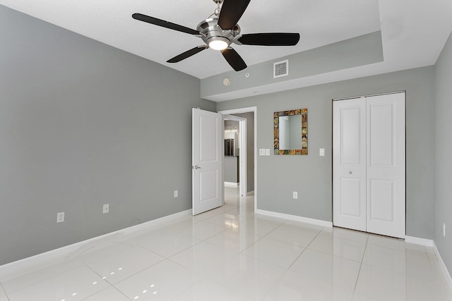 unfurnished bedroom featuring light tile patterned floors, a closet, visible vents, and baseboards