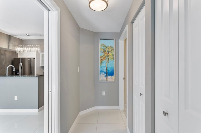 hallway featuring light tile patterned floors and baseboards