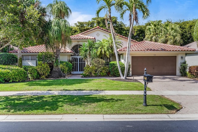 mediterranean / spanish house featuring a garage and a front lawn