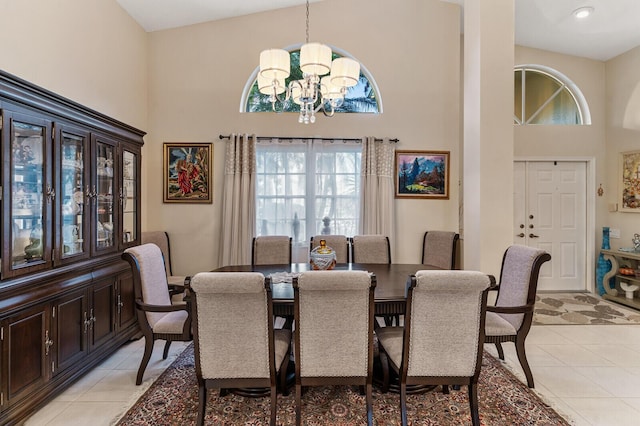 tiled dining room featuring a notable chandelier and a high ceiling