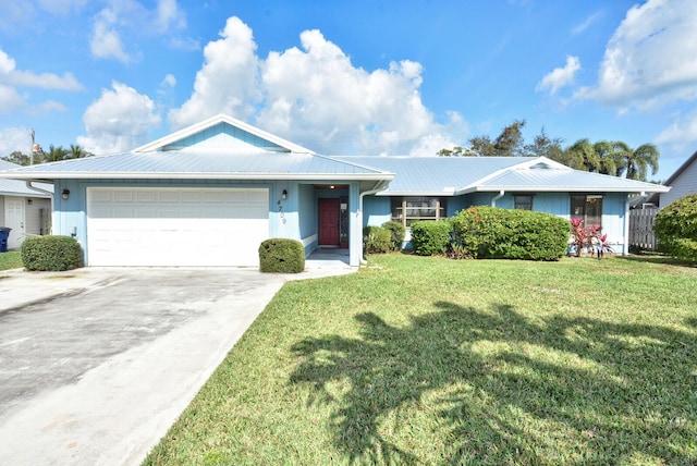 ranch-style home with a garage, metal roof, and a front lawn