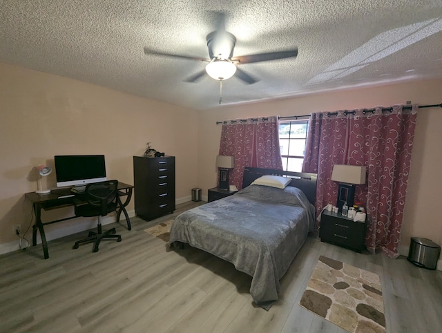 bedroom with ceiling fan, a textured ceiling, and light hardwood / wood-style flooring