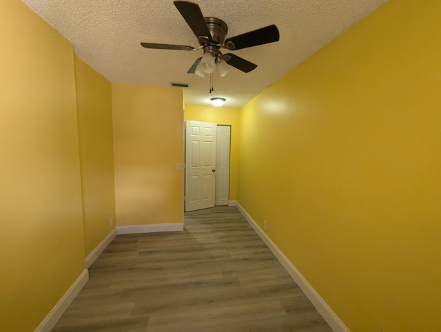 corridor featuring hardwood / wood-style flooring and a textured ceiling