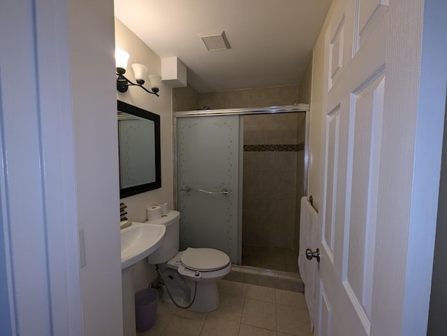 bathroom with an enclosed shower, tile patterned floors, and toilet