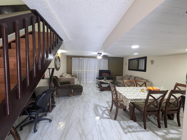 dining area featuring ceiling fan and a textured ceiling