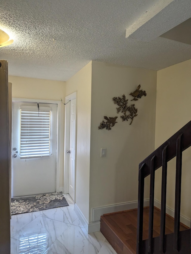 foyer entrance featuring a textured ceiling