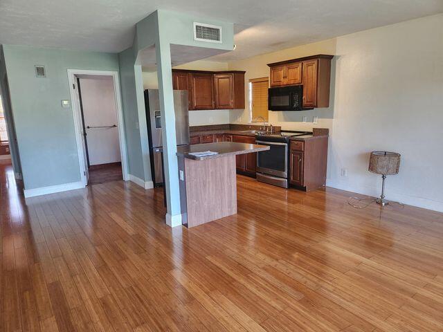 kitchen featuring stainless steel appliances, light hardwood / wood-style floors, and a center island