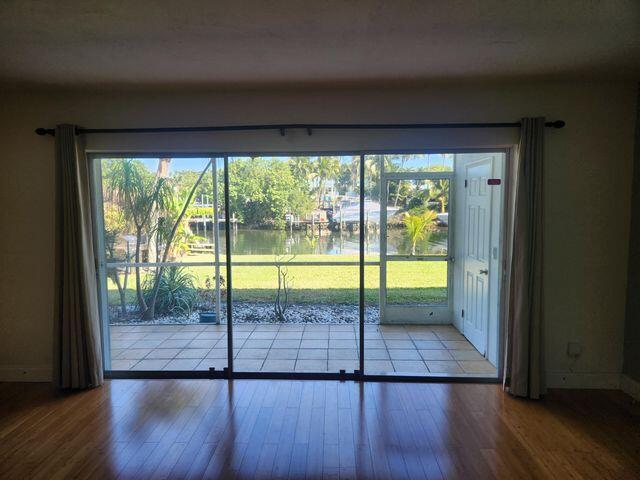 doorway to outside with wood-type flooring and a water view