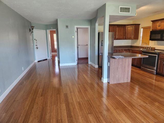 kitchen featuring appliances with stainless steel finishes, sink, hardwood / wood-style floors, and a kitchen island