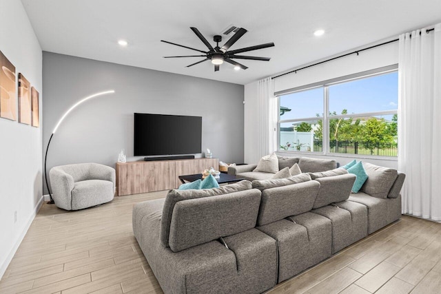 living room featuring ceiling fan and light wood-type flooring