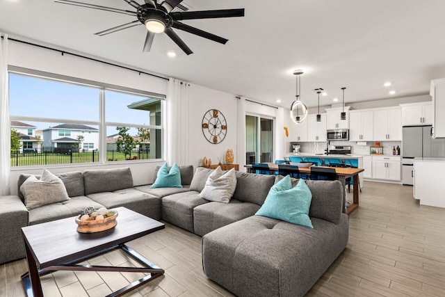 living room with ceiling fan and light hardwood / wood-style floors