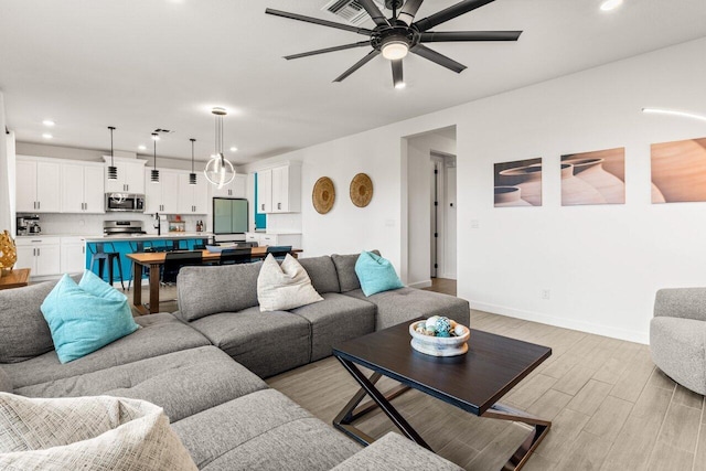 living room featuring light hardwood / wood-style floors and ceiling fan