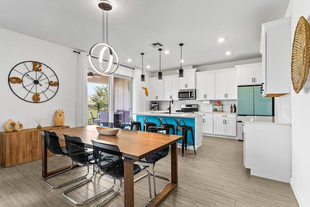 dining room featuring sink and light wood-type flooring