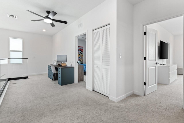 office space featuring light carpet and ceiling fan