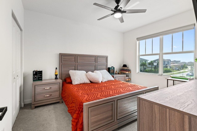 carpeted bedroom with ceiling fan and a closet