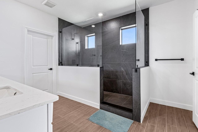 bathroom with vanity and a tile shower