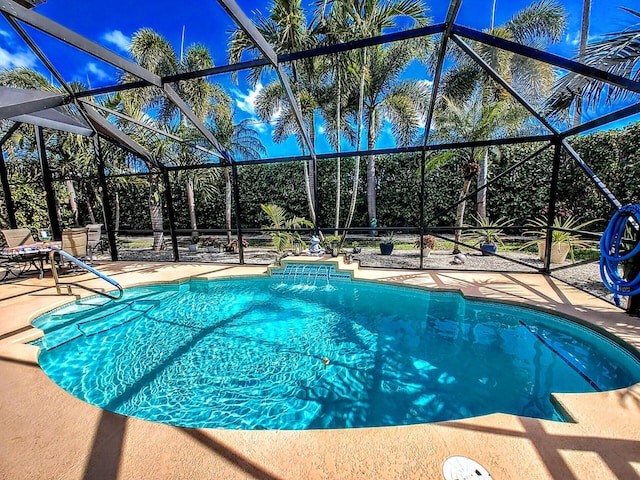 view of pool featuring glass enclosure and a patio area