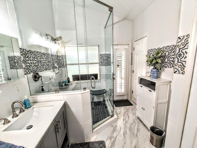 bathroom with tile walls, vanity, and a shower with shower door