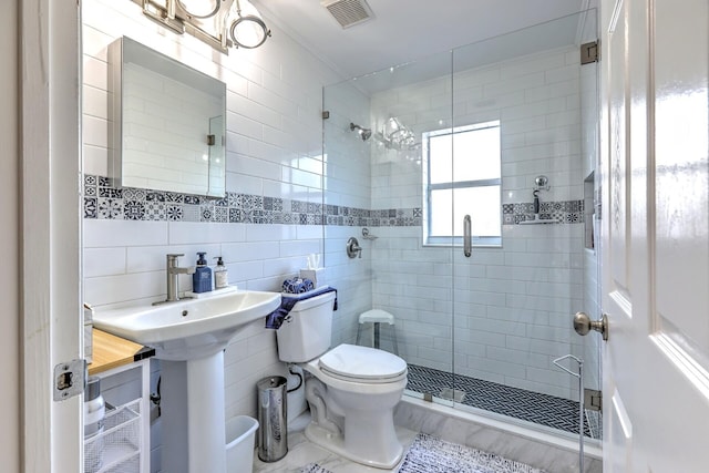 bathroom featuring tasteful backsplash, tile walls, toilet, and walk in shower