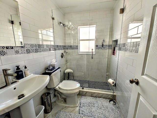 bathroom with a shower with shower door, sink, toilet, tile walls, and crown molding