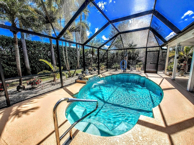 view of pool with pool water feature, a lanai, and a patio area