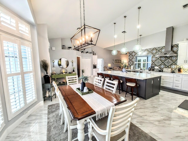 dining space featuring high vaulted ceiling