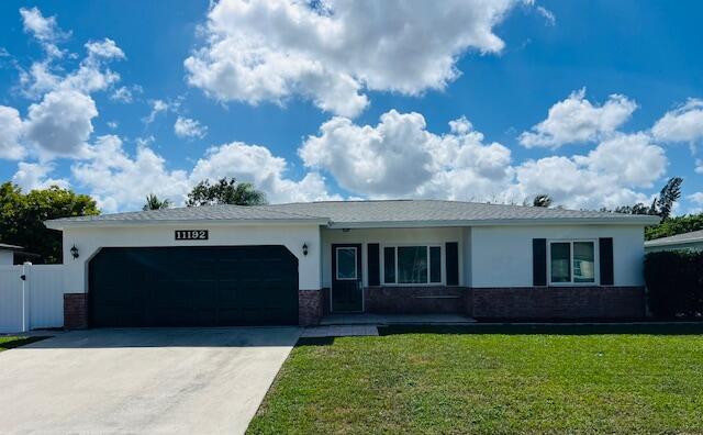 ranch-style house with a front yard and a garage