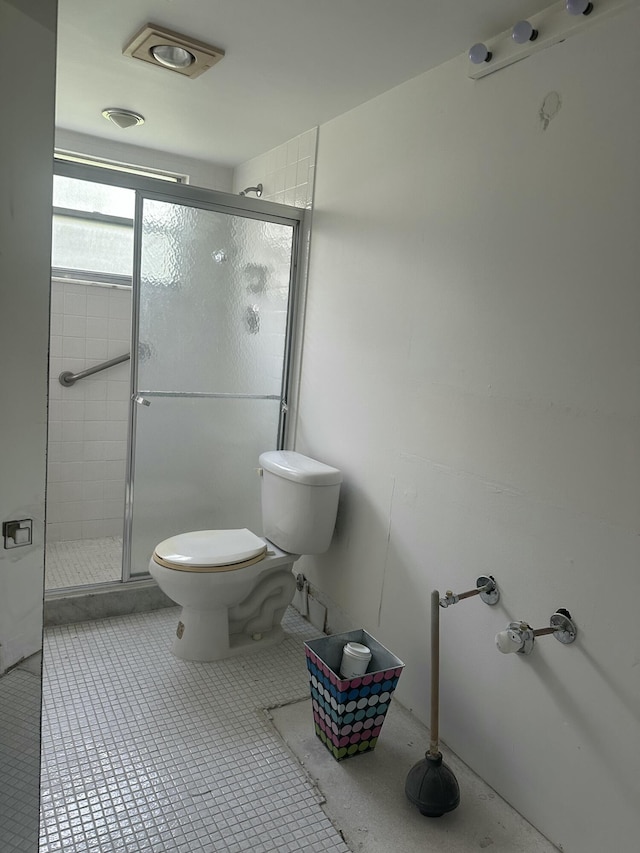 full bath featuring toilet, a stall shower, and tile patterned floors