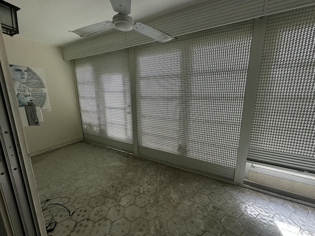 empty room with ceiling fan and tile patterned flooring