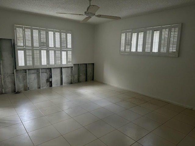 empty room featuring a ceiling fan and a textured ceiling