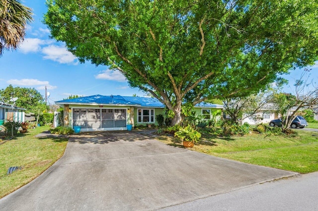 single story home with a garage, a front lawn, and concrete driveway